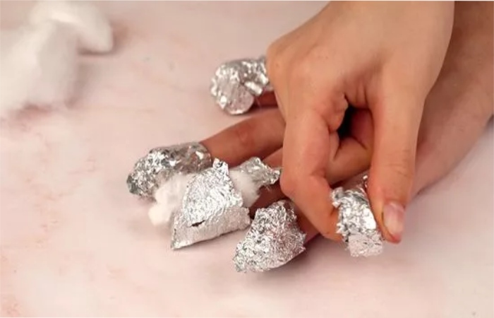 Wrap your nails with cotton and aluminum foil.